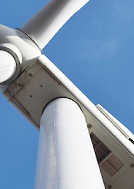 Close up of a wind turbine with the blue sky in the background